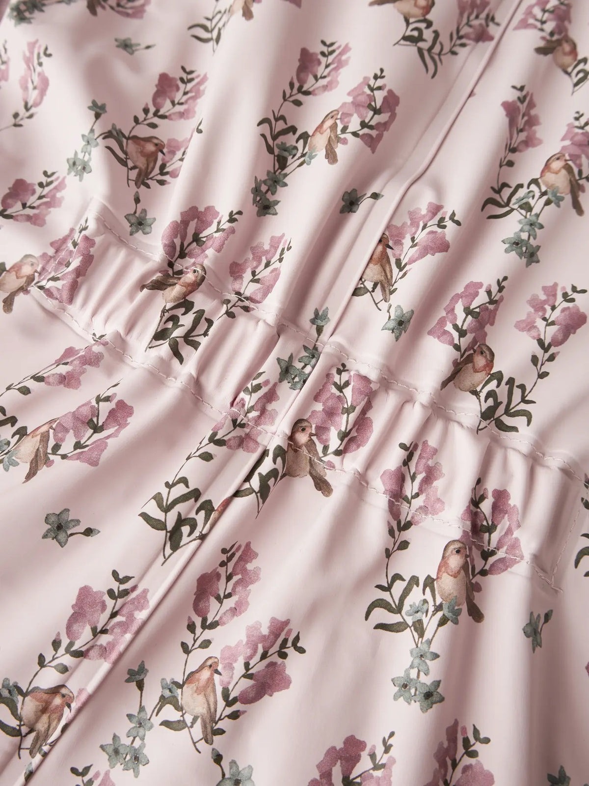 Detalj av blomster- og fuglemønster på Lil’ Atelier Ladry10 dress i Hushed Violet