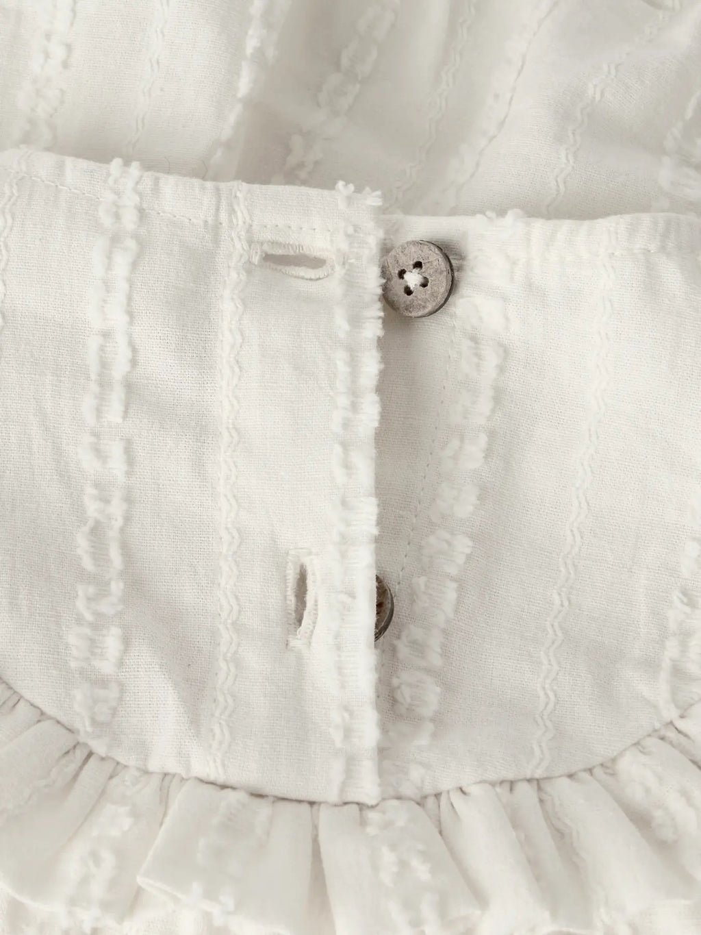 Detalj av knapper, volanger og stoffstruktur på Lil’ Atelier Frosea Fik romper i Turtledove