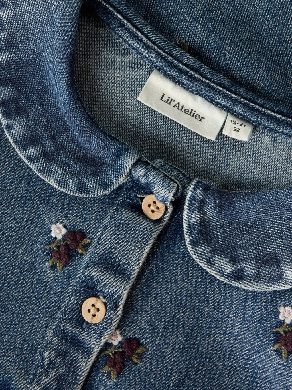 Detalj av krage, knapper og blomsterbroderi på Lil’ Atelier Roberta denimskjorte